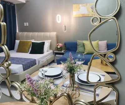 a living room with a couch and a table with a mirror at Elite Pod Manila in Manila