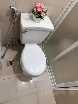 a bathroom with a toilet with a vase of flowers on it at Phebs 2bedroom Posh Condo in the heart of Makati in Manila
