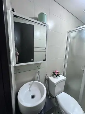 a bathroom with a sink and a toilet and a mirror at Phebs 2bedroom Posh Condo in the heart of Makati in Manila