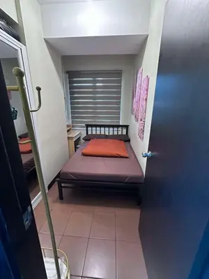a small bed in a small room with a window at Phebs 2bedroom Posh Condo in the heart of Makati in Manila
