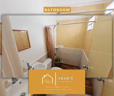 a bathroom with a shower and a toilet in a room at Arah Cozy House in Dasmariñas