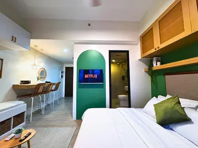 a hotel room with a bed and a kitchen and a bathroom at Urban Oasis Studio at Central District Makati in Manila