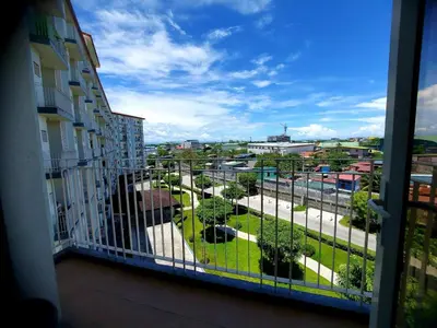 a balcony with a view of a park at Field Residences by Diane in Manila