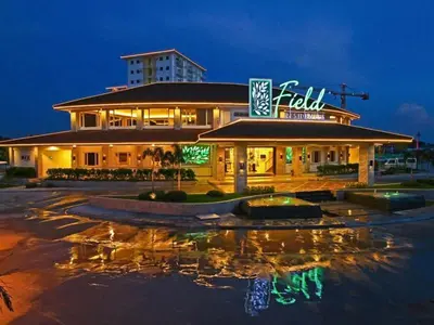a hotel with a reflection in a parking lot at night at Field Residences by Diane in Manila