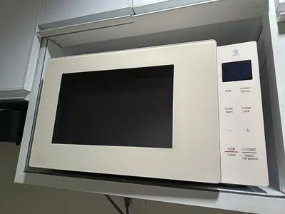 a white microwave oven sitting on a shelf at Paean's Pods at Bloom in Manila