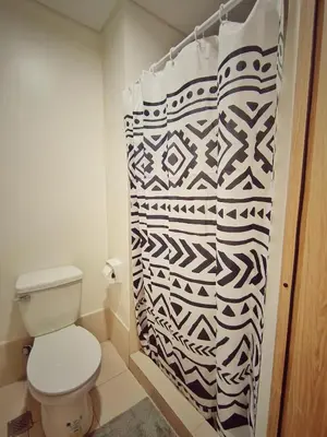 a bathroom with a toilet and a shower curtain at Paean's Pods at Bloom in Manila