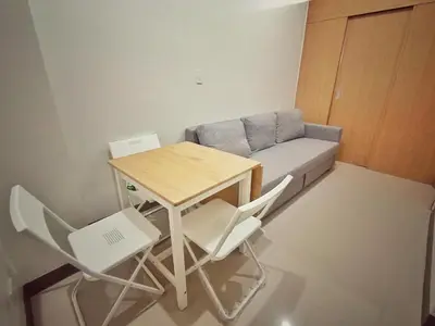 a small room with a table and chairs and a couch at Paean's Pods at Bloom in Manila