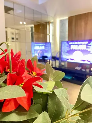 a plant with red flowers in a room with a television at Azure Cozy Hotel by CM staycation in Manila