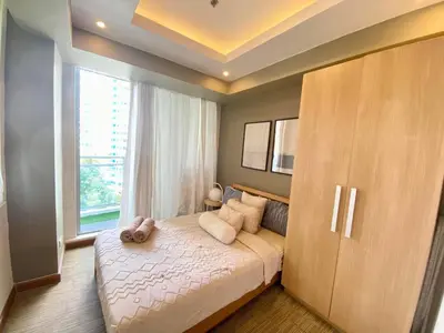 a bedroom with a large bed and a large window at Azure Cozy Hotel by CM staycation in Manila