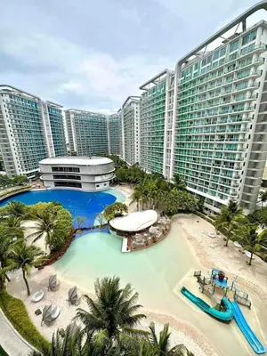 a large building with a swimming pool in front of it at Azure Cozy Hotel by CM staycation in Manila