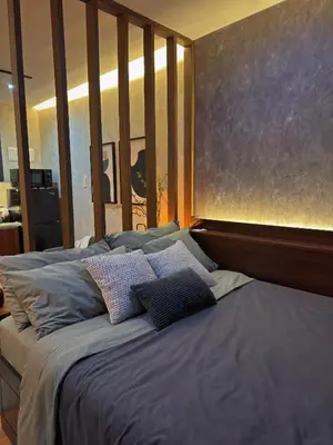 a bed with pillows on it in a bedroom at Sleek Designer Studio at Knightsbridge Residences in Manila