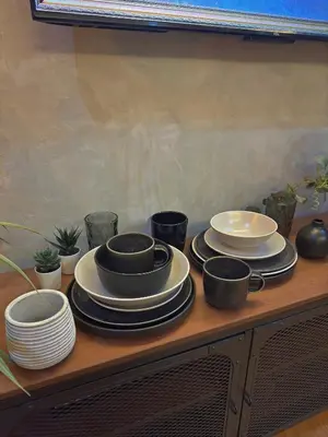 a table with plates and cups and dishes on it at Sleek Designer Studio at Knightsbridge Residences in Manila