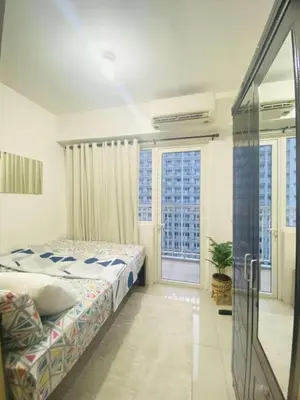 a bedroom with a bed and a large window at LiCa Place in Manila