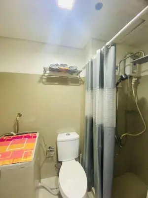 a bathroom with a shower with a toilet and a shower curtain at LiCa Place in Manila