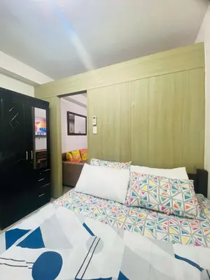 a bedroom with a large bed and a television at LiCa Place in Manila