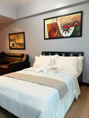 a bedroom with a large white bed and a couch at Airport View Walk to NAIA 3 in Manila