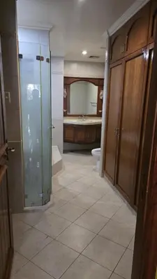 a bathroom with a shower and a toilet and a sink at Hassan Sisters' EnSuites in Manila