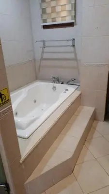 a bathroom with a bath tub in a room at Hassan Sisters' EnSuites in Manila