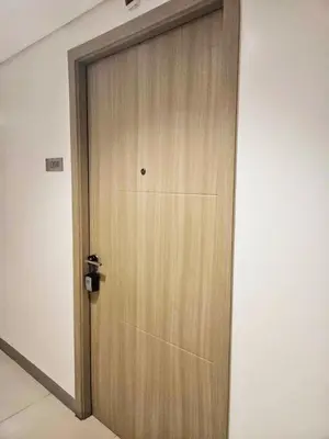a wooden door in a room with a wall at Cozy 1BR beside MOA with Wifi, Netflix, Pool & Washer in Manila