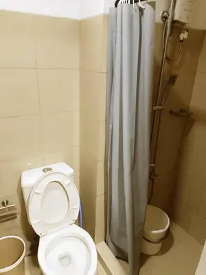 a bathroom with a toilet and a shower at Cozy 1BR beside MOA with Wifi, Netflix, Pool & Washer in Manila