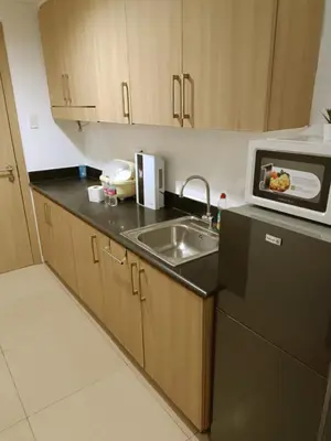 a kitchen with a sink and a microwave at Cozy 1BR beside MOA with Wifi, Netflix, Pool & Washer in Manila