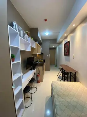a room with a bed and a desk and a table at Aral Realty and Property Management in Manila
