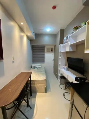 a room with a bed and a table and a desk at Aral Realty and Property Management in Manila