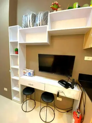 a desk with a monitor and two stools in a room at Aral Realty and Property Management in Manila