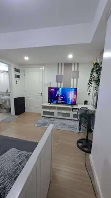 a living room with a flat screen tv on a wall at AZURE BICUTAN BACKPACKERS MAUI Tower in Manila