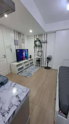 a living room with a flat screen tv and a kitchen at AZURE BICUTAN BACKPACKERS MAUI Tower in Manila