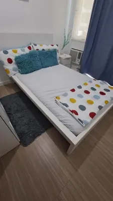 a bedroom with a bed with a blue curtain at AZURE BICUTAN BACKPACKERS MAUI Tower in Manila