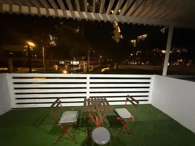 two chairs and a table on a balcony at night at AZURE BICUTAN BACKPACKERS MAUI Tower in Manila