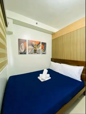 a bedroom with a blue bed with two napkins on it at Newly Furnished Staycation near Mall of Asia in Manila