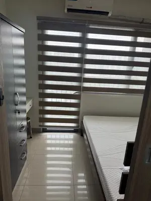 a room with two beds in front of a window at Newly Furnished Staycation near Mall of Asia in Manila