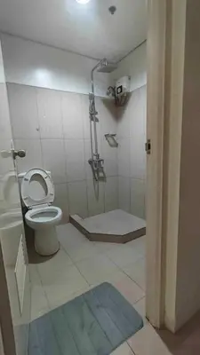 a bathroom with a toilet and a shower in it at 1148a 3br 1-king size 1queen size 2 double size 2-single size 1-extra matress Moa view in Manila