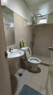 a bathroom with a toilet and a sink at 1148a 3br 1-king size 1queen size 2 double size 2-single size 1-extra matress Moa view in Manila