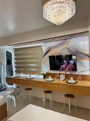 a room with a large table with chairs and a tv on the wall at Relax in Pasay Citys Best Kept Secret - Spacious Condo with Garden View in Manila