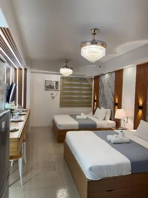 a hotel room with two beds and a desk at Relax in Pasay Citys Best Kept Secret - Spacious Condo with Garden View in Manila