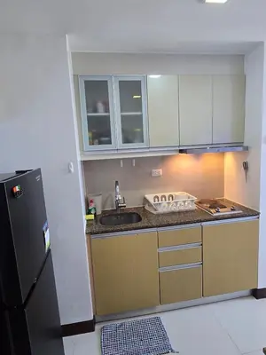 a small kitchen with a sink and a refrigerator at Cozy Corner Studio in McKinley Walk to Venice Mall in Manila