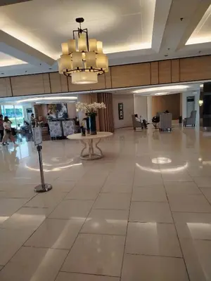 a large lobby with a table and a chandelier at Shell Residences MOA 2 beds by Dad's in Manila