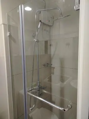 a shower in a bathroom with a glass door at Shell Residences MOA 2 beds by Dad's in Manila