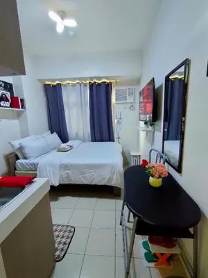 a small room with a bed and a table in it at Trisha's Condotel Urban Deca Tower Edsa in Manila