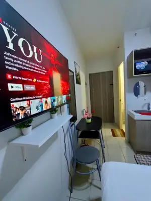 a bar with two stools and a large monitor on a wall at Trisha's Condotel Urban Deca Tower Edsa in Manila