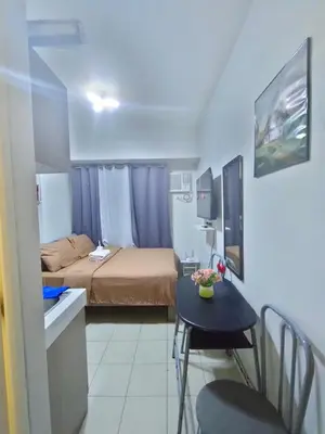 a small room with a bed and a small table at Trisha's Condotel Urban Deca Tower Edsa in Manila
