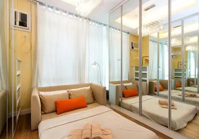 a living room with a couch and a mirror at Elegant 2BR Apartment in Upscale Fort BGC Fast Wifi in Manila