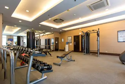 a gym with several treadmills and weights at Elegant 2BR Apartment in Upscale Fort BGC Fast Wifi in Manila