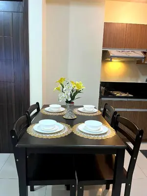 a black dining room table with plates and flowers on it at Bayfront Staycation at The Radiance Manila Pet-Friendly, Free Pool & Gym near Airport, MOA, Star City, Manila World Trade Center & Manila Bay in Manila
