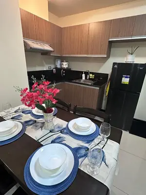 a dining room table with plates and wine glasses at Bayfront Staycation at The Radiance Manila Pet-Friendly, Free Pool & Gym near Airport, MOA, Star City, Manila World Trade Center & Manila Bay in Manila