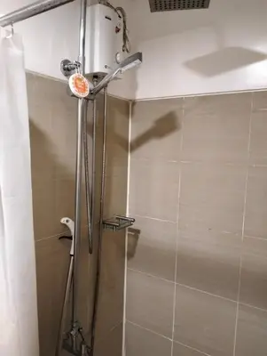 a shower in a bathroom with a shower curtain at Ellein's Crib At Moa in Manila