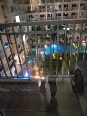 a view from the balcony of a building at night at Ellein's Crib At Moa in Manila